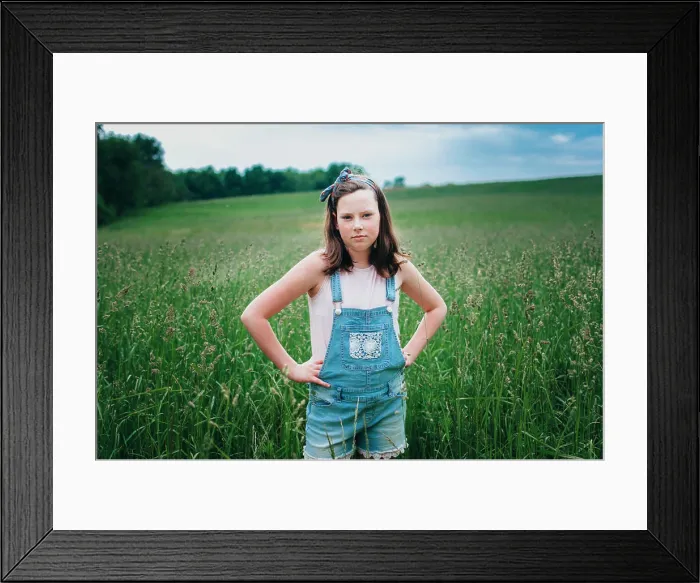 Framed Print : Teen Girl in Overall Shorts Standing in Grassy Field in the Midwest