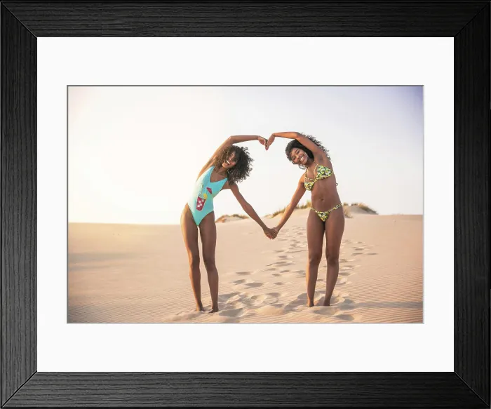 Framed Print : Laughing girlfriends showing heart with hands Framed Print : Laughing girlfriends showing heart with hands