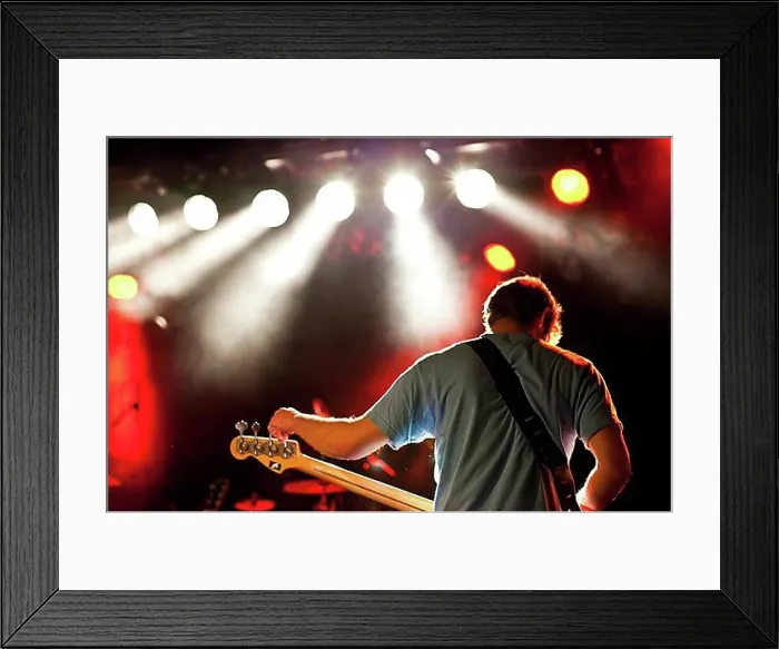 Framed Print : Bass player tuning his bass on stage Framed Print : Bass player tuning his bass on stage