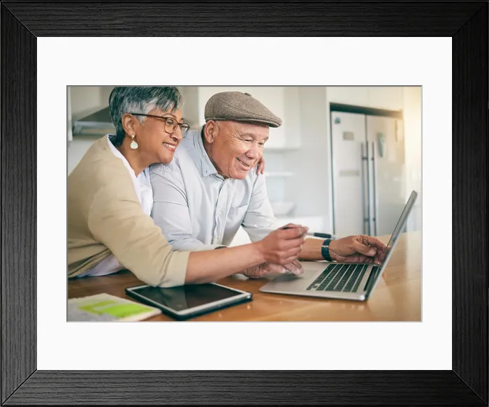 Framed Print : Laptop, happy and mature couple at table in home kitchen Framed Print : Laptop, happy and mature couple at table in home kitchen