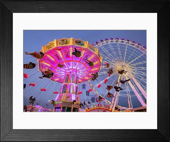Framed Print : A lively funfair at dusk, illuminated by a large Ferris wheel and a colourful chain carousel