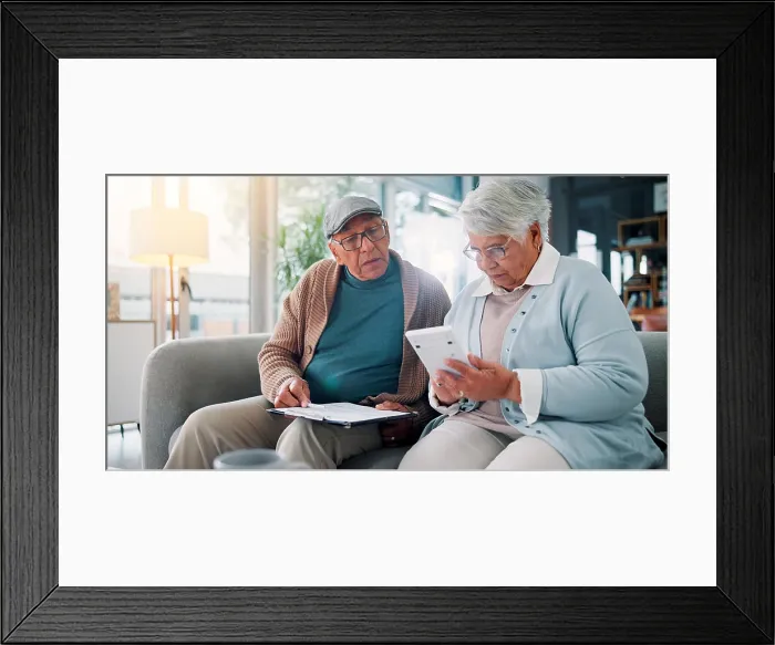 Framed Print : Senior couple, calculator and documents on couch with finance Framed Print : Senior couple, calculator and documents on couch with finance