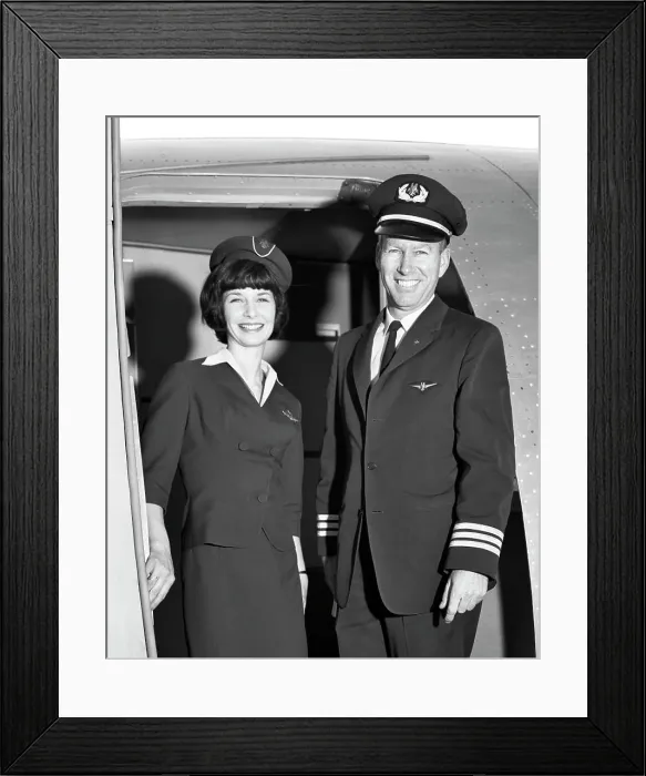 Framed Print : 1960s MAN CO-PILOT AND WOMAN FLIGHT ATTENDANT STANDING SMILING IN DOOR OF AIRPLANE LOOKING AT CAMERA Framed Print : 1960s MAN CO-PILOT AND WOMAN FLIGHT ATTENDANT STANDING SMILING IN DOOR OF AIRPLANE LOOKING AT CAMERA