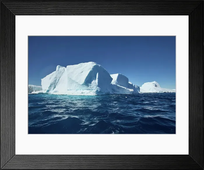 Framed Print : Majestic iceberg floating in a clear blue ocean under a bright sky