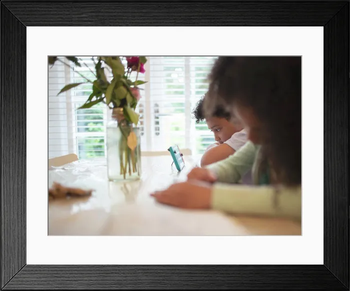 Framed Print : Boy with video game controller at table Framed Print : Boy with video game controller at table