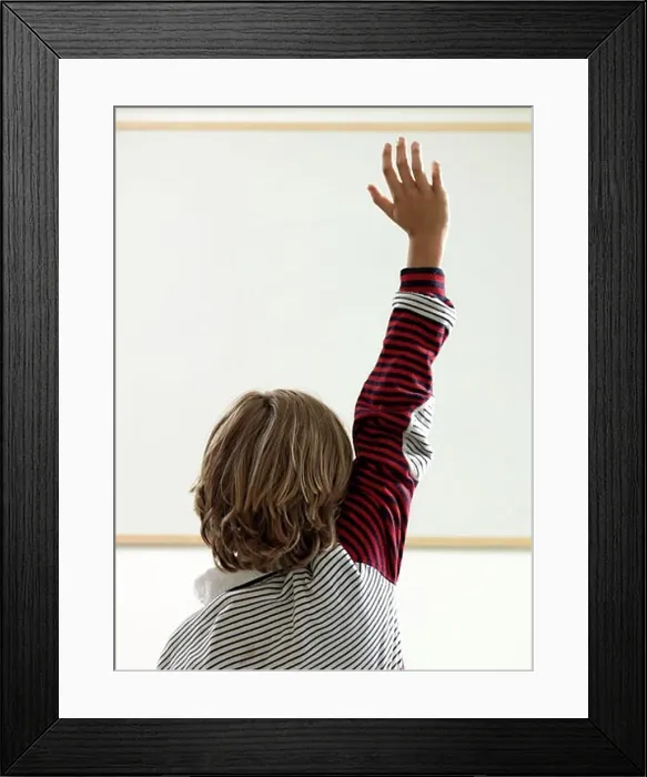 Framed Print : Boy raising hand in classroom