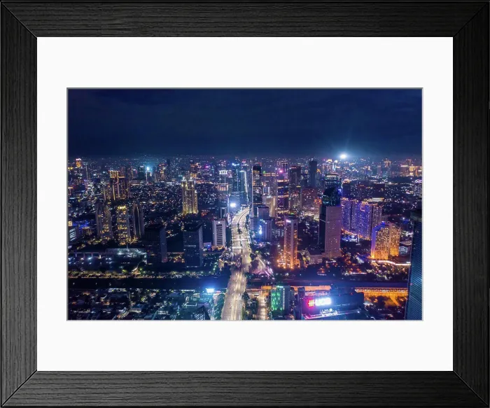 Framed Print : Aerial night cityscape of skyscrapers and multi lane highway traffic in modern city center of Jakarta Framed Print : Aerial night cityscape of skyscrapers and multi lane highway traffic in modern city center of Jakarta