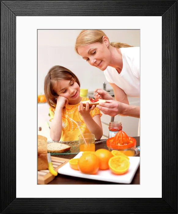 Framed Print : Child having breakfast or snack with her mother Framed Print : Child having breakfast or snack with her mother