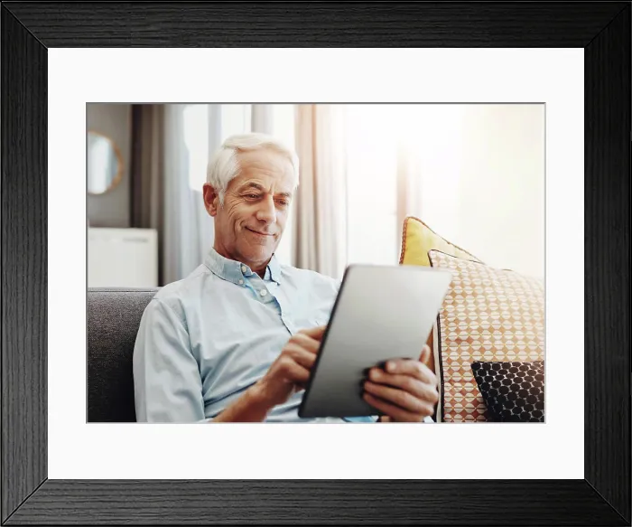 Framed Print : Senior man, technology and relax on sofa in home for typing email Framed Print : Senior man, technology and relax on sofa in home for typing email