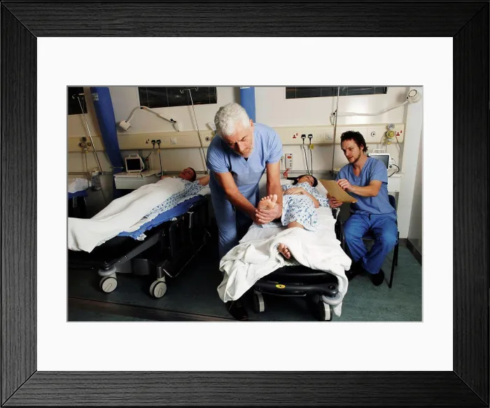Framed Print : Bearded surgeon checking female patient in hospital bed Framed Print : Bearded surgeon checking female patient in hospital bed