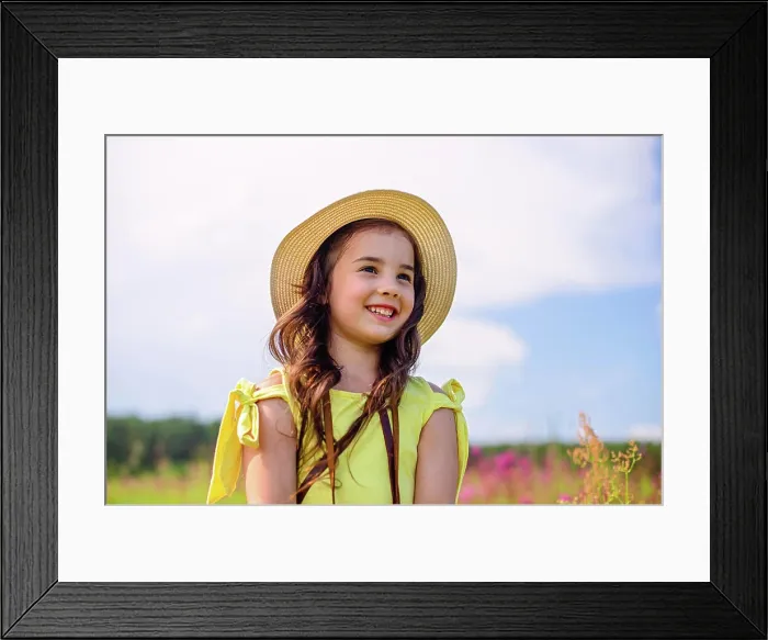 Framed Print : Ein lächelndes süßes Mädchen mit Strohhut steht in der Natur im Sommer Framed Print : Ein lächelndes süßes Mädchen mit Strohhut steht in der Natur im Sommer