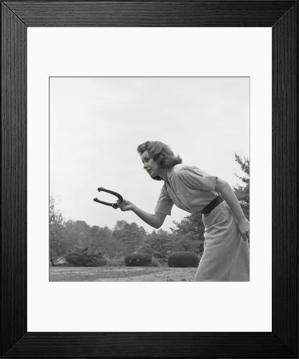 Framed Print : Young woman playing a game of horseshoes Framed Print : Young woman playing a game of horseshoes