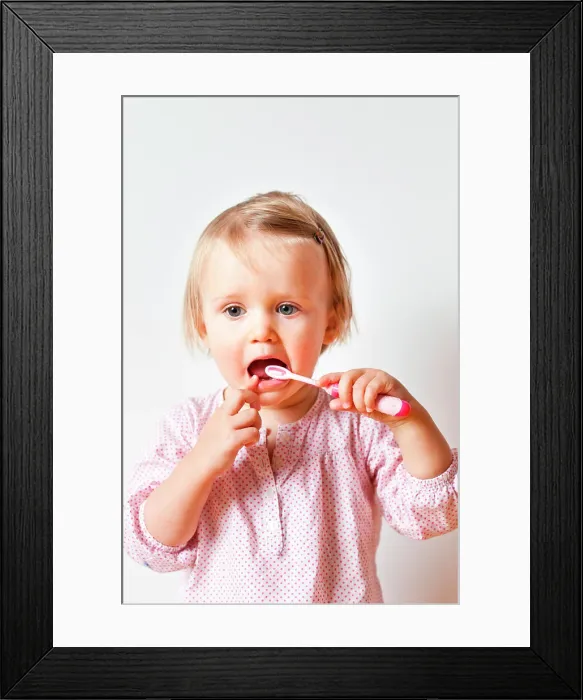 Framed Print : 18 month old baby girl brushing her teeth