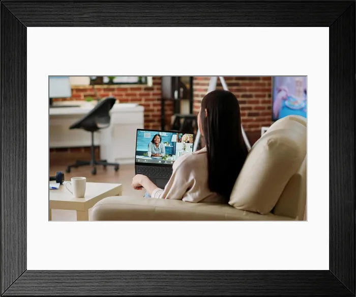Framed Print : Young woman working remotely from home while attending virtual meeting teleconference on laptop