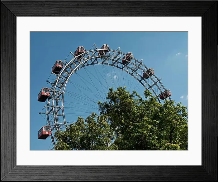 Framed Print : Large Ferris wheel with red cabins behind trees in an amusement park under a blue sky, Vienna, Austria, Europe Framed Print : Large Ferris wheel with red cabins behind trees in an amusement park under a blue sky, Vienna, Austria, Europe