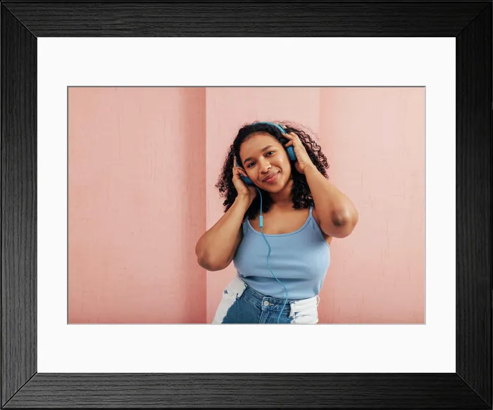 Framed Print : Plus Größe Frau Blick auf die Kamera trägt blaue Kopfhörer gegen eine rosa Wand Plus size woman looking at camera Framed Print : Plus Größe Frau Blick auf die Kamera trägt blaue Kopfhörer gegen eine rosa Wand Plus size woman looking at camera