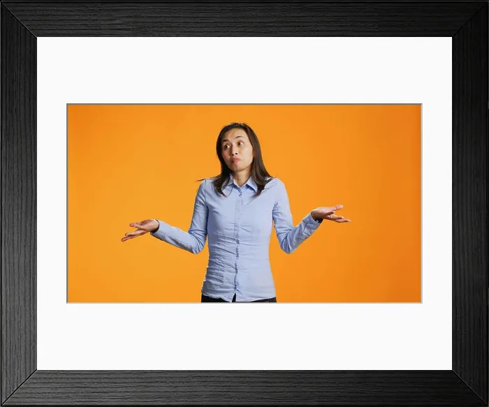 Framed Print : Doubtful model raising shoulders over orange background