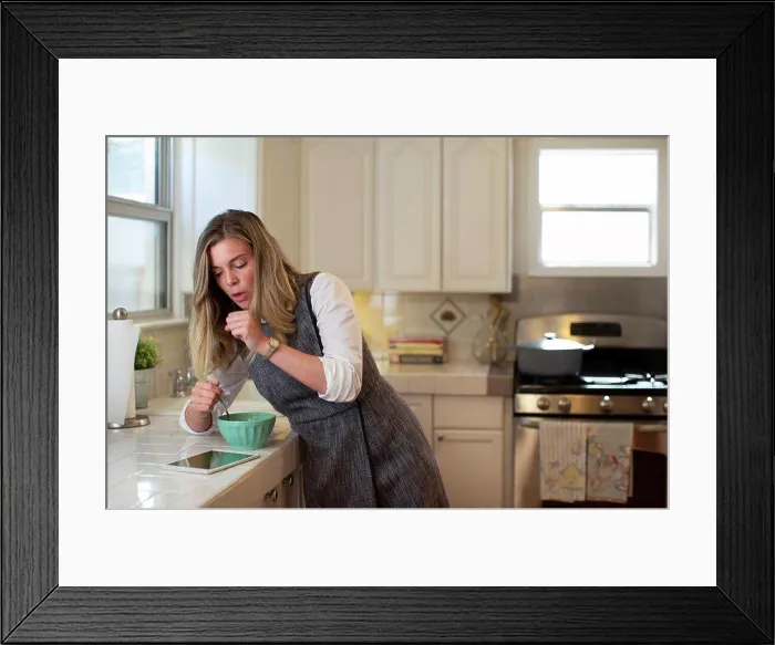 Framed Print : Coughing young woman in her kitchen, eating breakfast getting on her iPad Framed Print : Coughing young woman in her kitchen, eating breakfast getting on her iPad