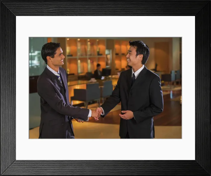 Framed Print : Businessmen shaking hands in bar