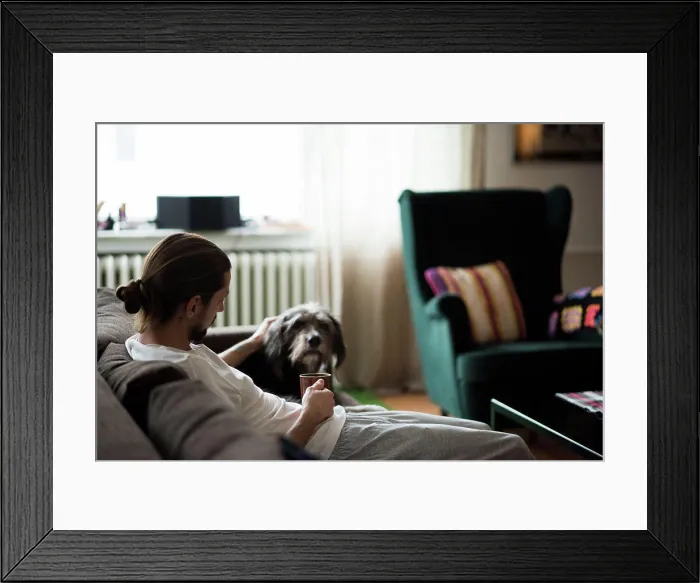 Framed Print : Man with dachshund relaxing on sofa