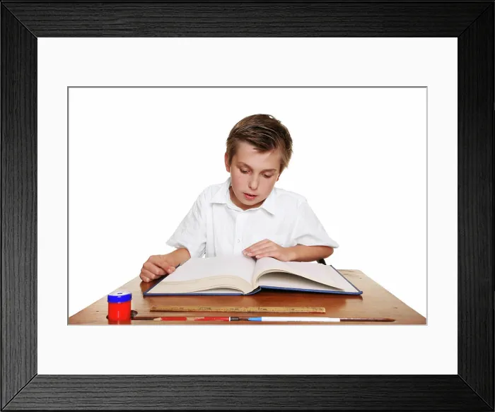 Framed Print : School student reading a book. A school child reading a book or studying Framed Print : School student reading a book. A school child reading a book or studying