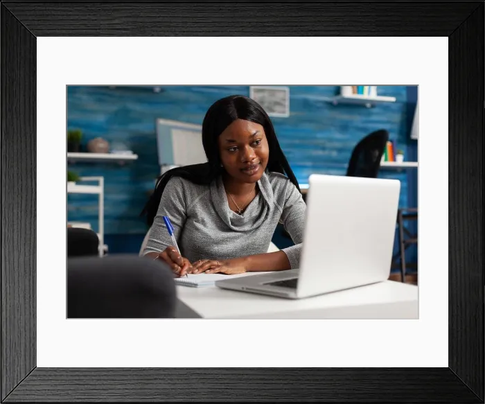 Framed Print : Young person taking notes on textbook paper with pen