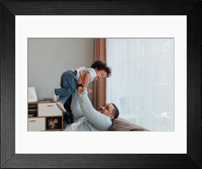 Framed Print : Lächelnder Vater, der seinen Sohn hochhebt
