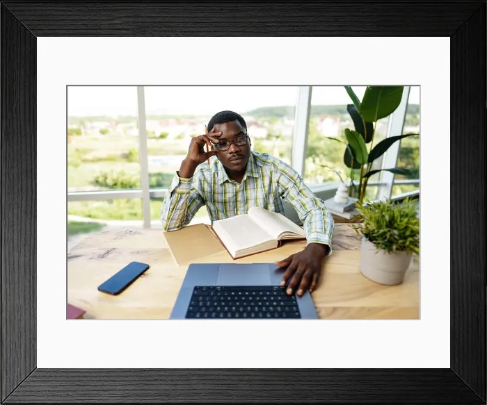 Framed Print : Serious concentrated african man studying or working with laptop indoors Framed Print : Serious concentrated african man studying or working with laptop indoors