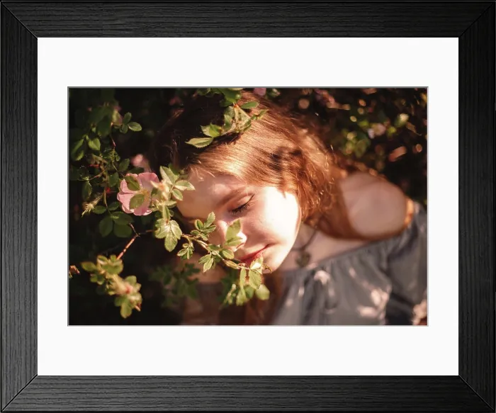 Framed Print : Peaceful young woman sitting amidst flowers in park during summer