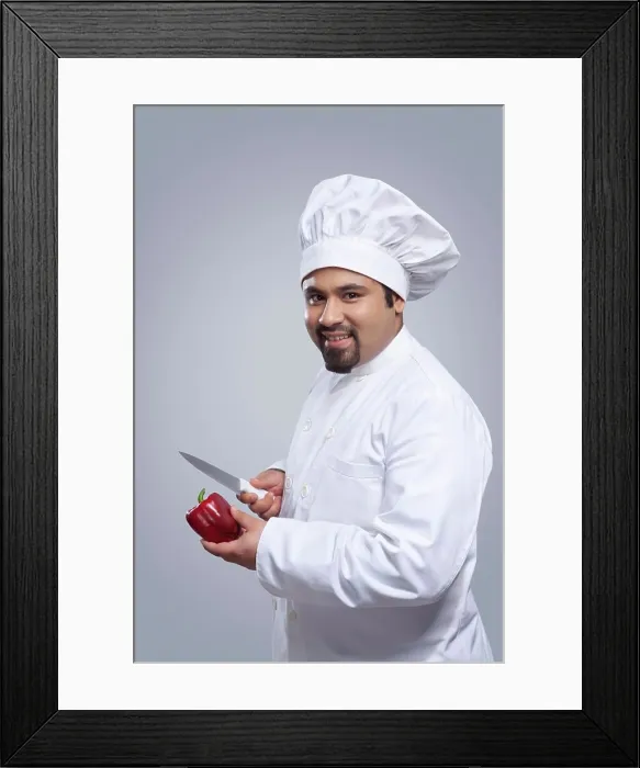 Framed Print : Portrait of chef with capsicum and knife Framed Print : Portrait of chef with capsicum and knife