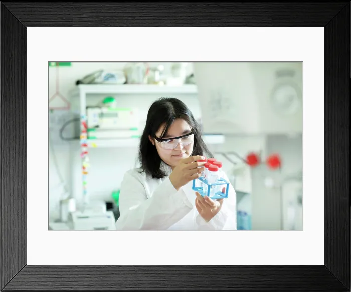 Framed Print : young scientist female controlling a tube in a rack Framed Print : young scientist female controlling a tube in a rack