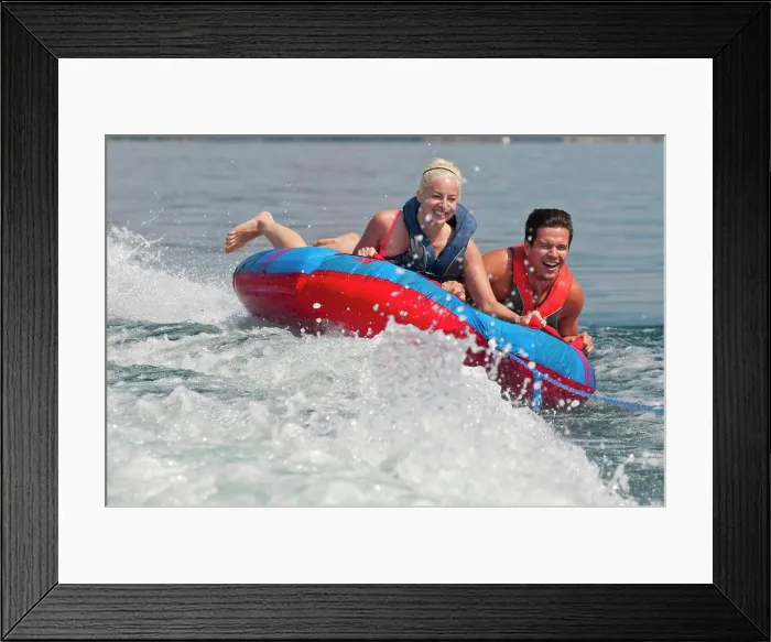 Framed Print : Brett and Kali laugh as they hold on tight to the tube as it is pulled behind the boat, on Kalamalka Lake, BC Framed Print : Brett and Kali laugh as they hold on tight to the tube as it is pulled behind the boat, on Kalamalka Lake, BC