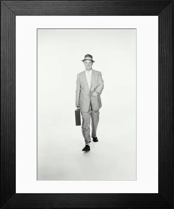 Framed Print : Vintage Photograph. A studio shot of a man wearing a suit and holding a briefcase walking towards the camera. Frame 1 Framed Print : Vintage Photograph. A studio shot of a man wearing a suit and holding a briefcase walking towards the camera. Frame 1