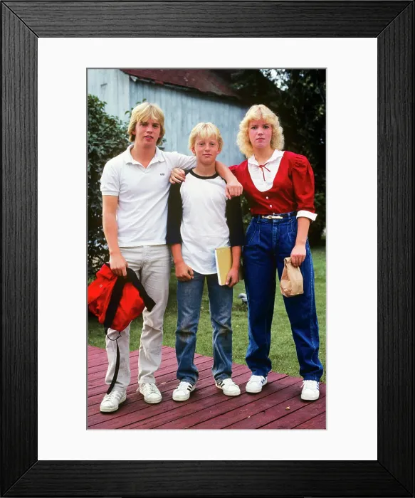 Framed Print : 1980s THREE BLOND TEENAGERS BROTHERS SISTERS STANDING TOGETHER LOOKING AT CAMERA ON FIRST DAY OF SCHOOL