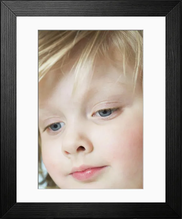 Framed Print : A cute little girl looking down, extreme close-up