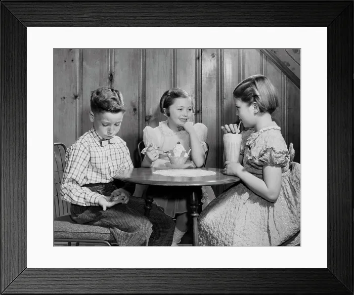 Framed Print : Boy sitting with two girls in a restaurant and counting money Framed Print : Boy sitting with two girls in a restaurant and counting money