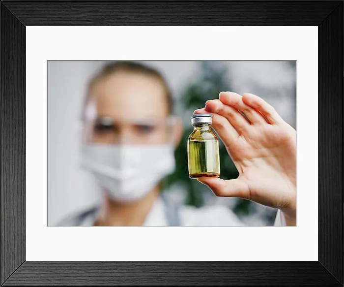 Framed Print : Front view female researcher with vaccine bottle Framed Print : Front view female researcher with vaccine bottle