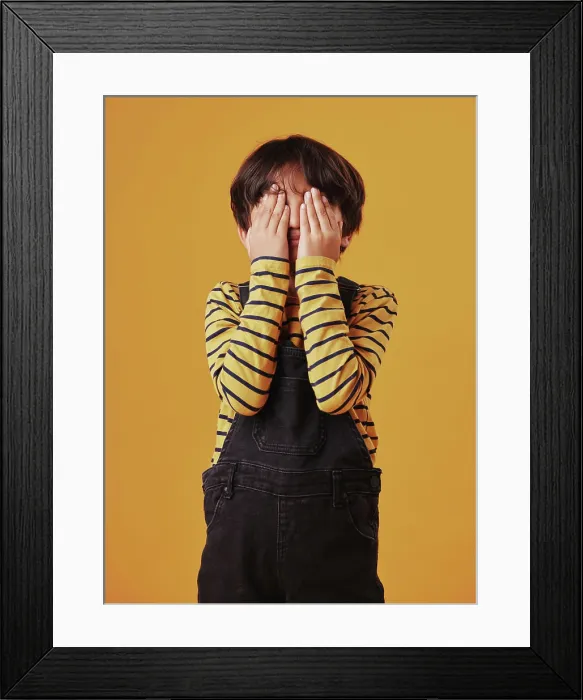 Framed Print : Hands, peekaboo or shy with child on yellow background Framed Print : Hands, peekaboo or shy with child on yellow background