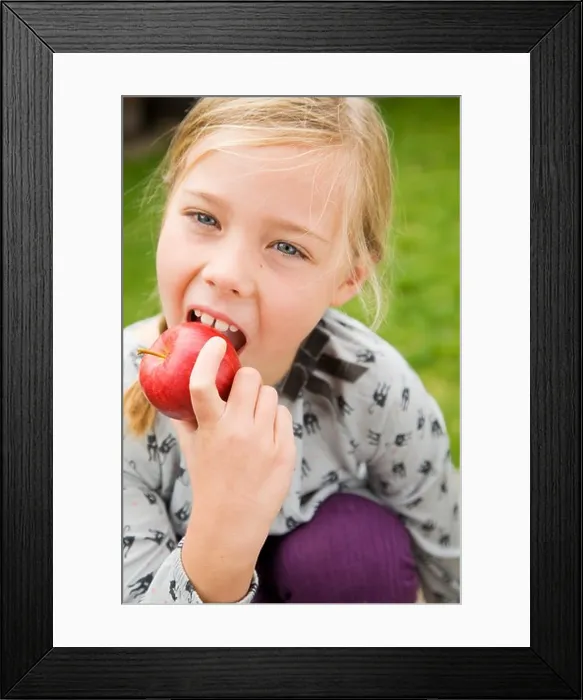 Framed Print : Girl eating fruit outdoors Framed Print : Girl eating fruit outdoors