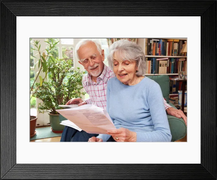 Framed Print : Happy Senior Couple Reviewing Finances At Home Framed Print : Happy Senior Couple Reviewing Finances At Home