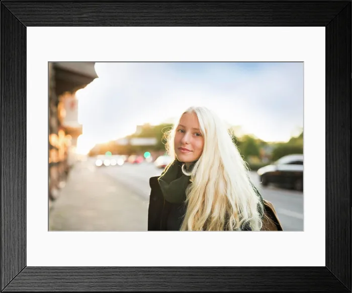 Framed Print : Young woman smiles gently on a city street at sunset Framed Print : Young woman smiles gently on a city street at sunset