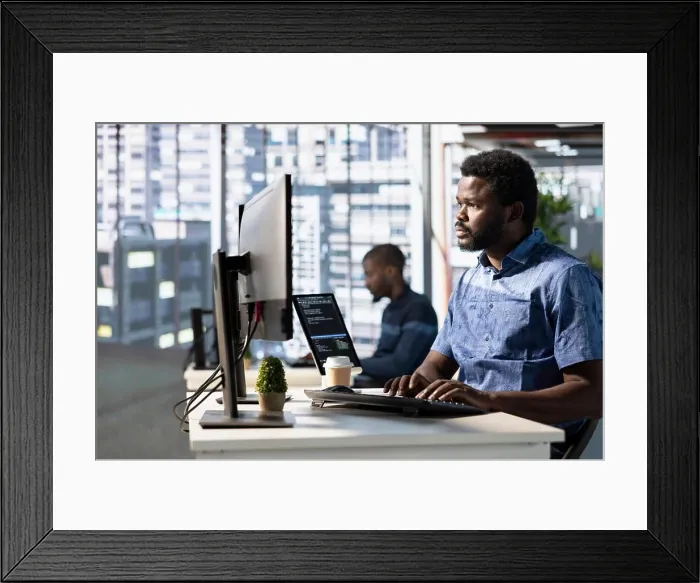 Framed Print : Focused employee analyzing datasets Framed Print : Focused employee analyzing datasets