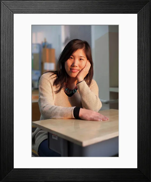 Framed Print : A young woman sits at a desk in a classroom, beijing, china