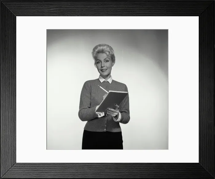 Framed Print : Vintage Photograph. Woman smiles while taking notes Framed Print : Vintage Photograph. Woman smiles while taking notes