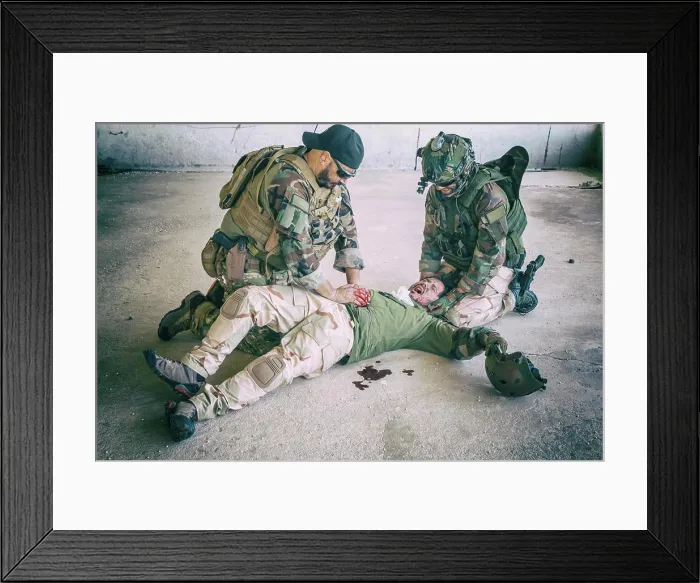 Framed Print : Soldiers giving emergency care to a wounded comrade lying on the floor, screaming in pain Framed Print : Soldiers giving emergency care to a wounded comrade lying on the floor, screaming in pain