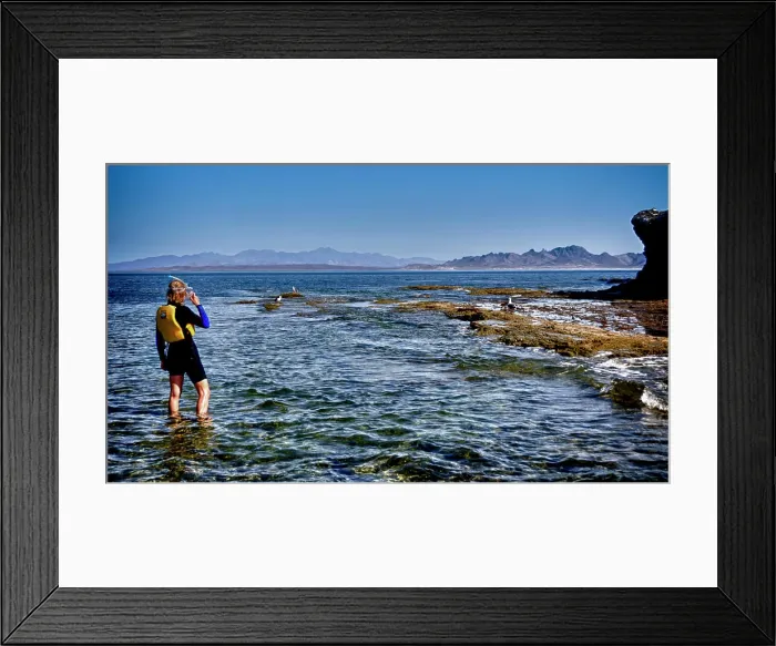 Framed Print : Isla de Espiritu Santo, Baja, Mexico, Woman snorkeler studies the rocks and surf. (MR) Framed Print : Isla de Espiritu Santo, Baja, Mexico, Woman snorkeler studies the rocks and surf. (MR)