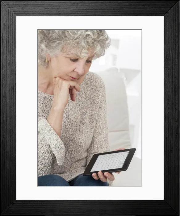 Framed Print : Senior woman reading an ebook