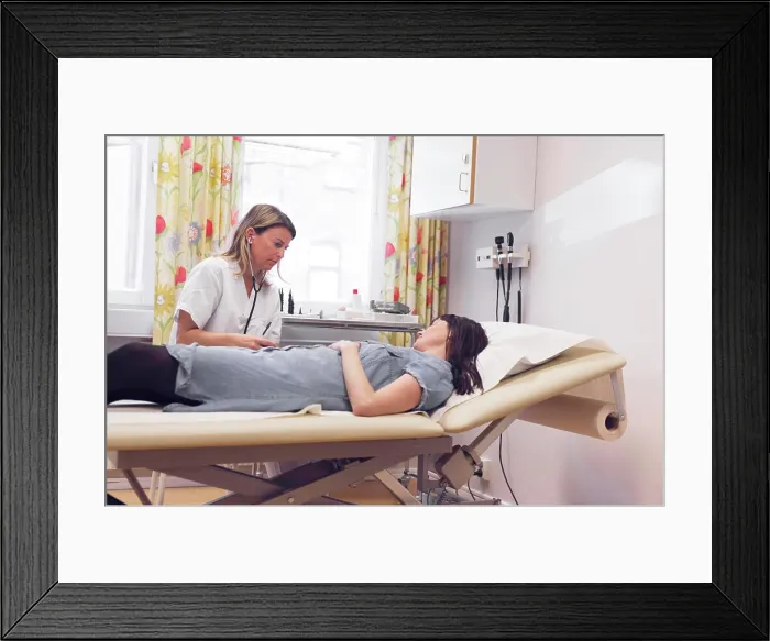 Framed Print : A patient consults with a healthcare professional in a bright medical office