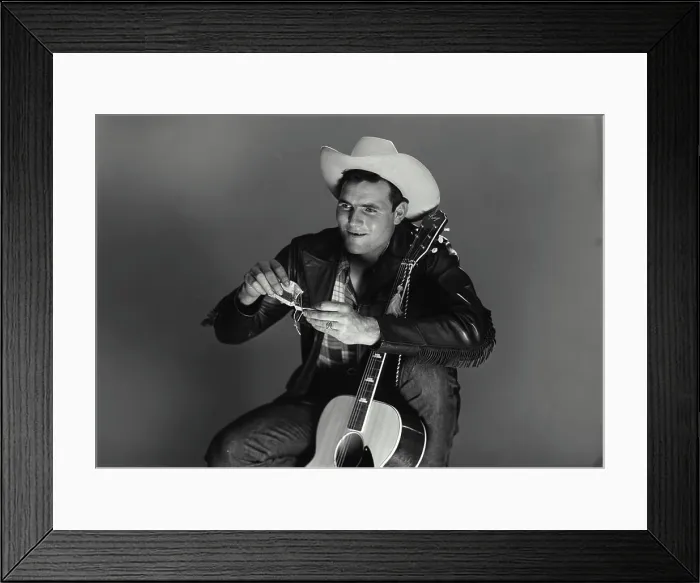 Framed Print : Vintage Photograph. Man sits with guitar as he rolls up a ciggarette Framed Print : Vintage Photograph. Man sits with guitar as he rolls up a ciggarette