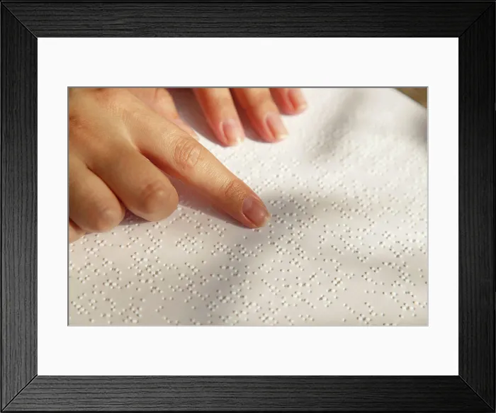 Framed Print : Woman's hand on a book page with braille. Female finger Framed Print : Woman's hand on a book page with braille. Female finger